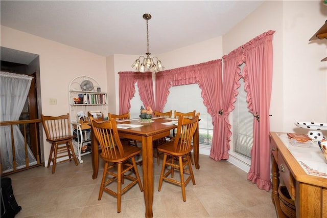 dining area with a chandelier and light tile patterned floors
