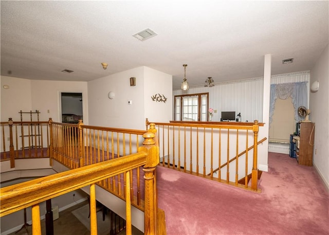 corridor with an upstairs landing, carpet floors, and baseboards