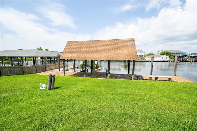 surrounding community with a boat dock, a yard, a water view, and boat lift
