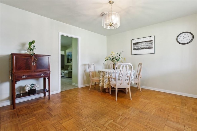 dining room with a chandelier and baseboards