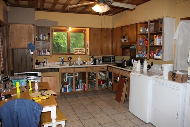 21508 Weinberger Rd, Ponchatoula, LA 70454 - kitchen featuring washing machine and clothes dryer, stainless steel microwave, under cabinet range hood, a sink, and light tile patterned flooring
