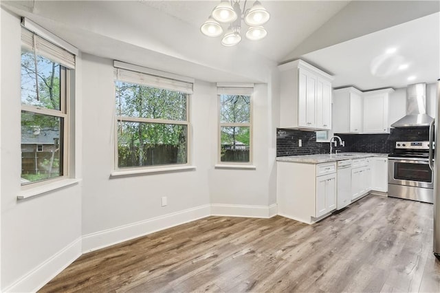 kitchen with wall chimney range hood, electric stove, healthy amount of natural light, dishwasher, and lofted ceiling