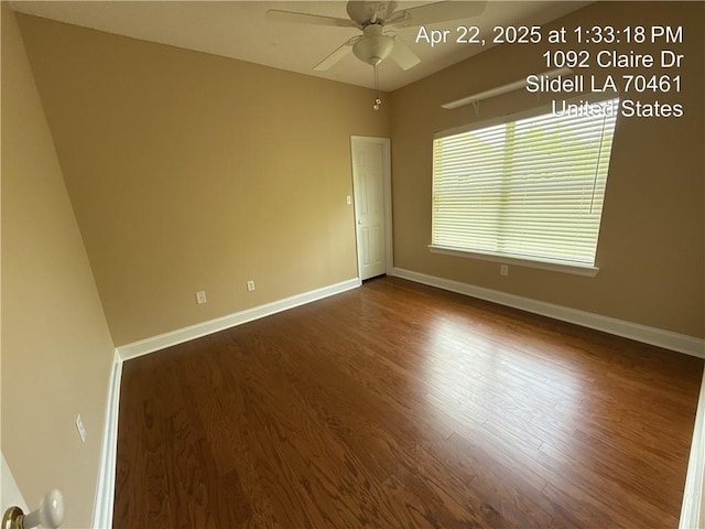 empty room featuring dark wood finished floors, baseboards, and ceiling fan