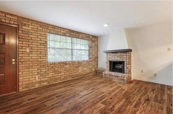 2305 Cleary Ave Unit 106, Metairie, LA 70001 - unfurnished living room with wood finished floors, a brick fireplace, brick wall, and baseboards