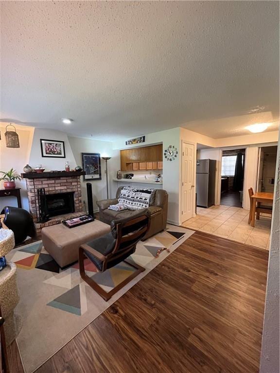 2305 Cleary Ave Unit 106, Metairie, LA 70001 - living area with a textured ceiling, a fireplace, and light wood finished floors