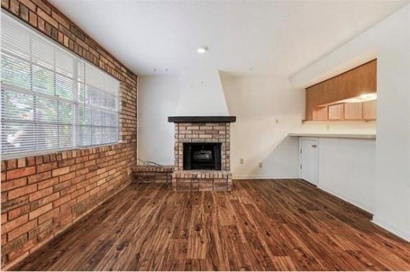 2305 Cleary Ave Unit 106, Metairie, LA 70001 - unfurnished living room featuring a fireplace, dark wood-style flooring, brick wall, and recessed lighting