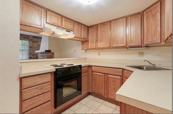2305 Cleary Ave Unit 106, Metairie, LA 70001 - kitchen with black electric range oven, under cabinet range hood, light countertops, and light tile patterned flooring