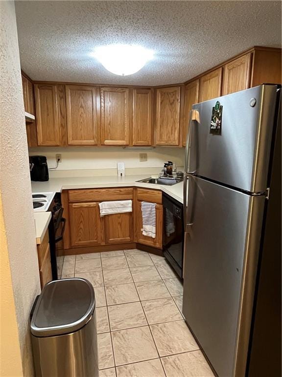 2305 Cleary Ave Unit 106, Metairie, LA 70001 - kitchen with freestanding refrigerator, black dishwasher, range with electric cooktop, brown cabinets, and light countertops
