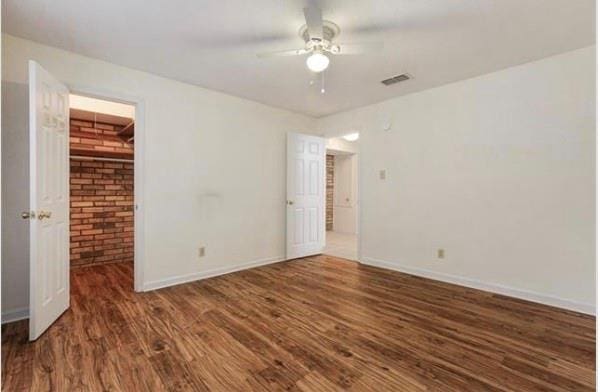 2305 Cleary Ave Unit 106, Metairie, LA 70001 - unfurnished bedroom with wood finished floors, baseboards, ceiling fan, and brick wall
