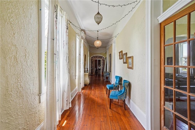 2334 Marengo St, New Orleans, LA 70115 - hall featuring arched walkways, a textured wall, wood-type flooring, and baseboards