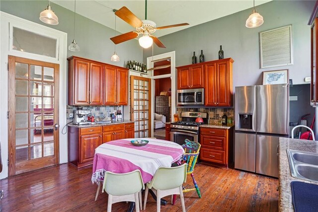 2334 Marengo St, New Orleans, LA 70115 - kitchen featuring appliances with stainless steel finishes, dark wood-style flooring, ceiling fan, and backsplash