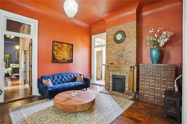 2334 Marengo St, New Orleans, LA 70115 - living area featuring hardwood / wood-style floors, a wood stove, and a brick fireplace
