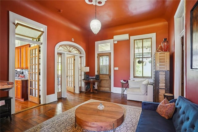 2334 Marengo St, New Orleans, LA 70115 - living area with hardwood / wood-style flooring, an AC wall unit, baseboards, and french doors