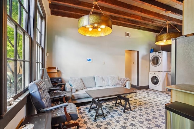 2334 Marengo St, New Orleans, LA 70115 - living room with stacked washer and clothes dryer, beam ceiling, and a towering ceiling