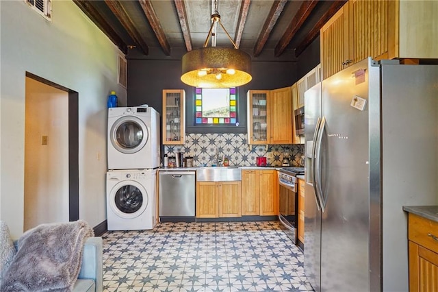 2334 Marengo St, New Orleans, LA 70115 - kitchen with estacked washer and dryer, stainless steel appliances, light floors, a sink, and tasteful backsplash
