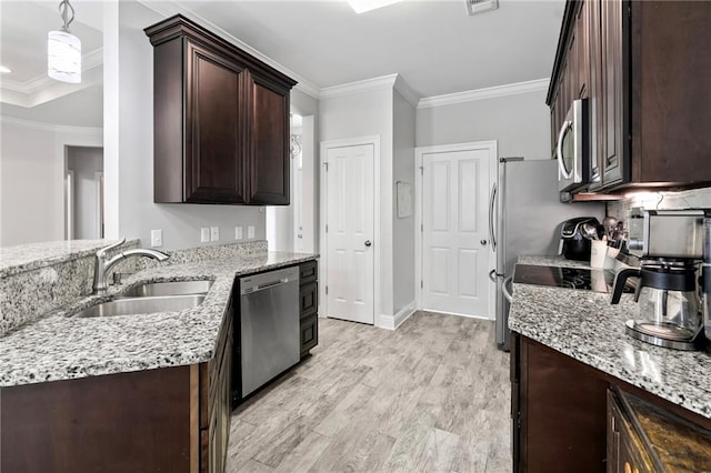 kitchen featuring appliances with stainless steel finishes, a sink, crown molding, dark brown cabinets, and light stone counters