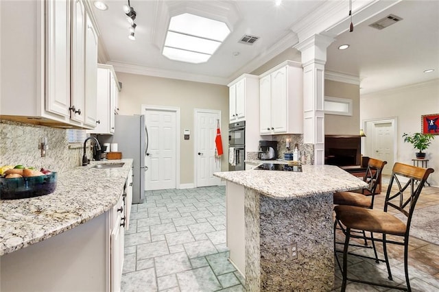 410 Doctor Gorman Dr, Belle Chasse, LA 70037 - kitchen featuring a breakfast bar area, a sink, black appliances, decorative backsplash, and crown molding