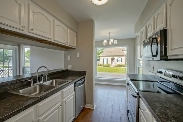 147 W Chamale Cv Unit 147, Slidell, LA 70460 - kitchen featuring stainless steel appliances, a sink, dark countertops, baseboards, and a chandelier