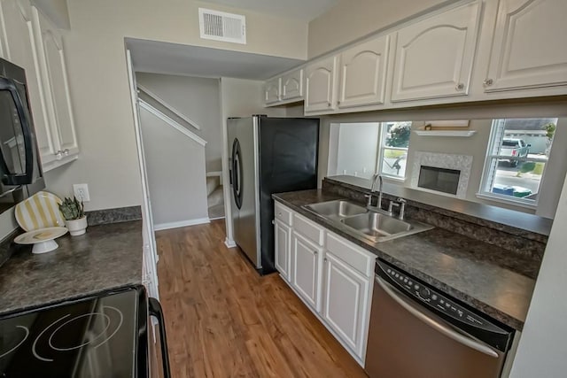147 W Chamale Cv Unit 147, Slidell, LA 70460 - kitchen featuring stainless steel appliances, a sink, dark countertops, white cabinetry, and wood finished floors