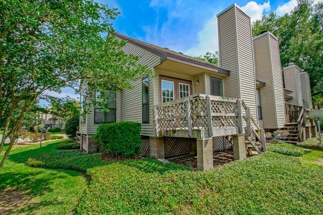 147 W Chamale Cv Unit 147, Slidell, LA 70460 - back of property with stairway, a deck, a chimney, and a lawn