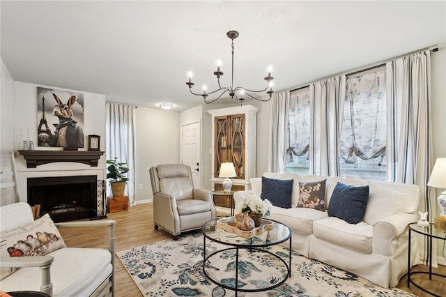 740 Heavens Dr Unit 8, Mandeville, LA 70471 - living area featuring a chandelier, light wood-style flooring, a fireplace with raised hearth, and baseboards