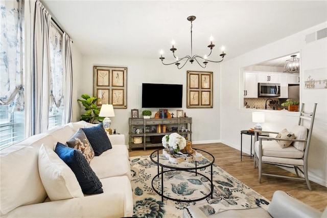740 Heavens Dr Unit 8, Mandeville, LA 70471 - living area featuring a chandelier, wood finished floors, and baseboards