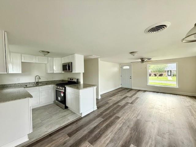 559 Resor Ave, Harahan, LA 70123 - kitchen featuring appliances with stainless steel finishes, a sink, open floor plan, and light wood finished floors