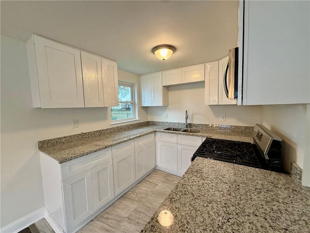 559 Resor Ave, Harahan, LA 70123 - kitchen featuring stainless steel appliances, white cabinetry, light stone counters, and light marble finish floors