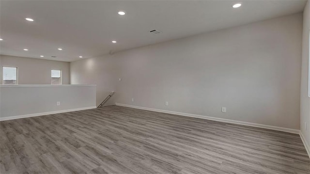 empty room with wood finished floors, recessed lighting, and baseboards