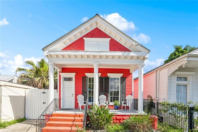 view of front of home featuring covered porch and fence