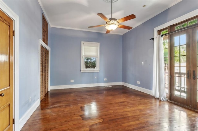 spare room with crown molding, wood finished floors, french doors, a ceiling fan, and baseboards
