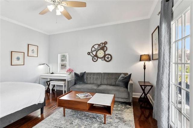 living area with crown molding, wood finished floors, a ceiling fan, and baseboards