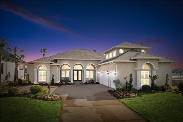 2283 Sunset Blvd, Slidell, LA 70461 - mediterranean / spanish-style home featuring driveway, a garage, stucco siding, french doors, and a front yard