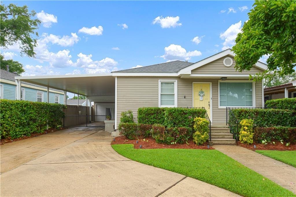 712 Tullulah Ave, River Ridge, LA 70123 - view of front of house with driveway, an attached carport, and a front yard