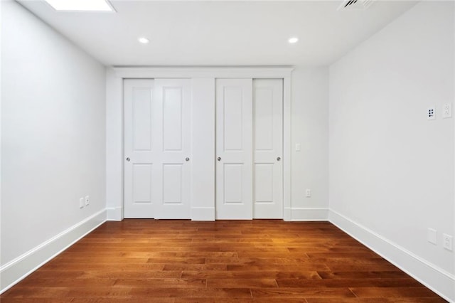 700 Magazine St Unit 513, New Orleans, LA 70130 - unfurnished bedroom featuring baseboards, dark wood-style floors, a closet, and recessed lighting
