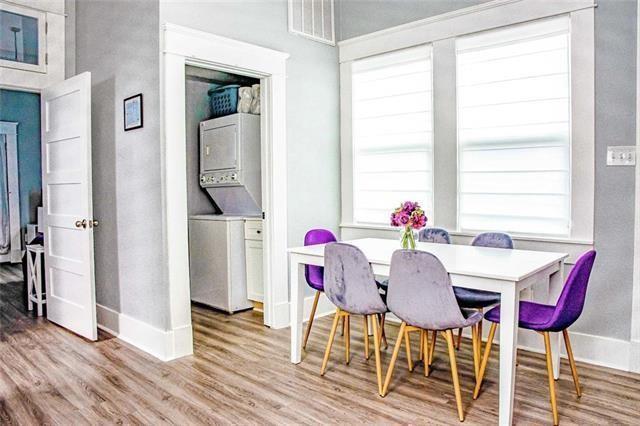 4226 S Carrollton Ave, New Orleans, LA 70119 - dining room with stacked washing machine and dryer, baseboards, wood finished floors, and plenty of natural light