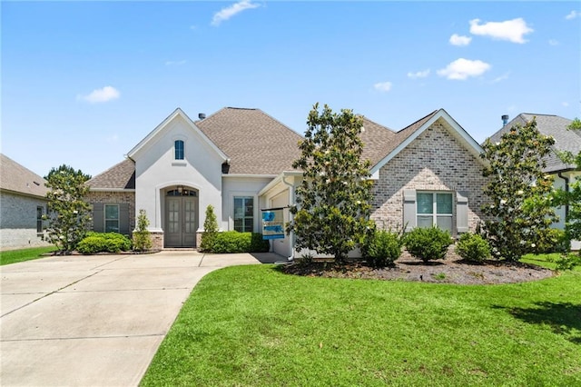 2021 Cypress Bend Dr, Madisonville, LA 70447 - french country inspired facade with brick siding, french doors, a front yard, and roof with shingles