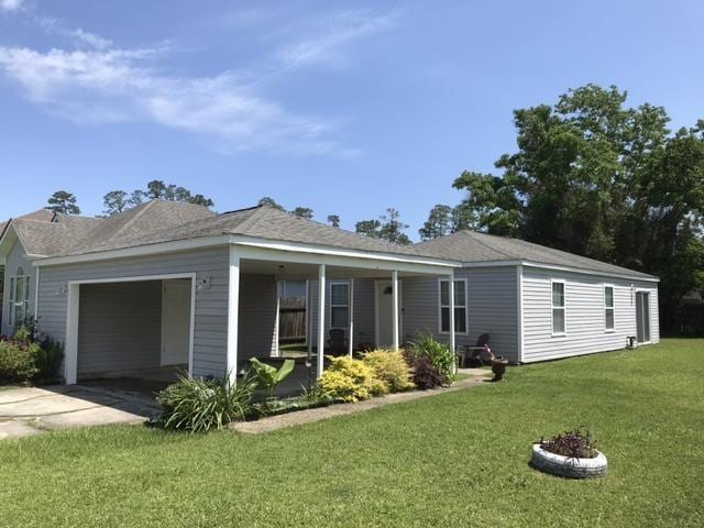 view of front of property with an attached garage, concrete driveway, a front lawn, and covered porch