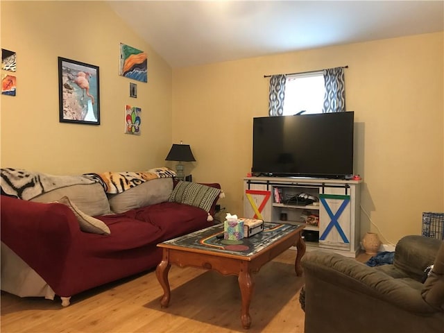 living room featuring wood finished floors and lofted ceiling