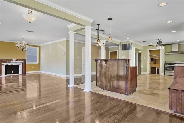 3630 Octavia St, New Orleans, LA 70125 - kitchen with stainless steel range, freestanding refrigerator, wall chimney range hood, recessed lighting, and baseboards