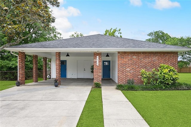 view of front of property featuring concrete driveway, brick siding, a carport, and roof with shingles