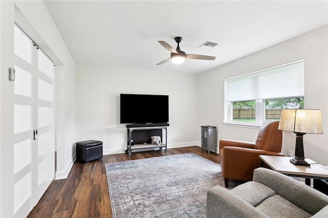 living room featuring a ceiling fan, dark wood-style flooring, and baseboards