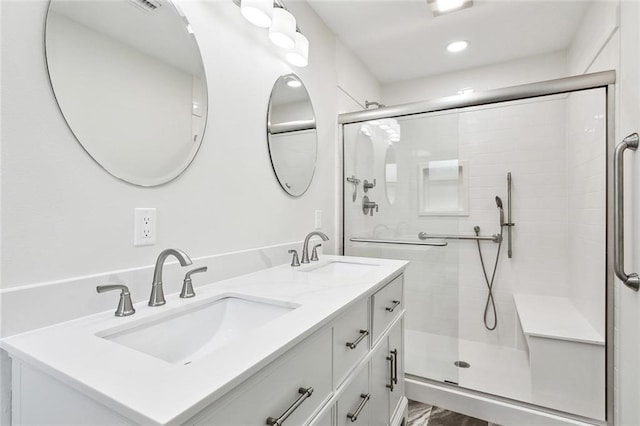 bathroom featuring a stall shower, double vanity, and recessed lighting