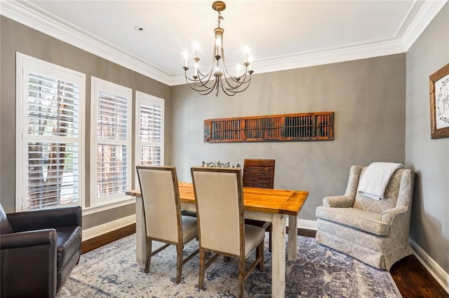 dining space featuring a chandelier, wood finished floors, baseboards, and crown molding