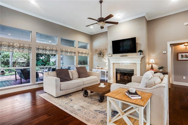 living room featuring a ceiling fan, dark wood-type flooring, crown molding, recessed lighting, and a tile fireplace