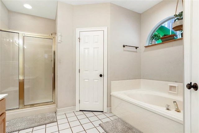 bathroom with tile patterned floors, a stall shower, a bath, baseboards, and vanity