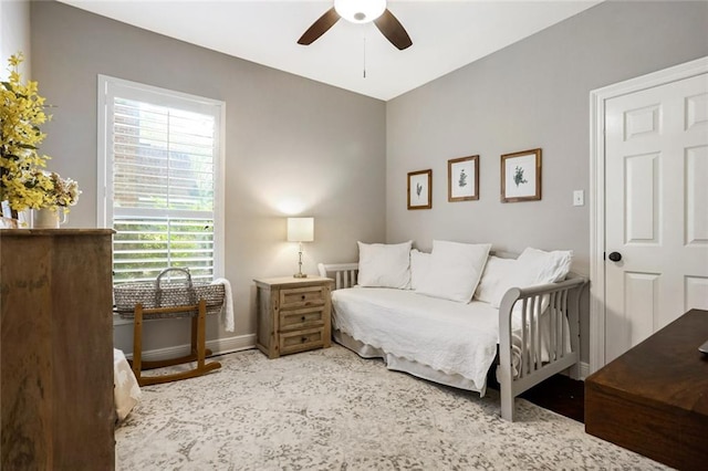 bedroom featuring multiple windows, baseboards, and ceiling fan