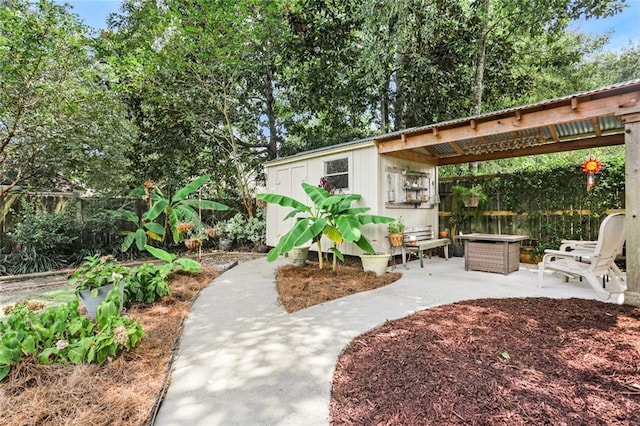 view of patio / terrace featuring fence and an outbuilding