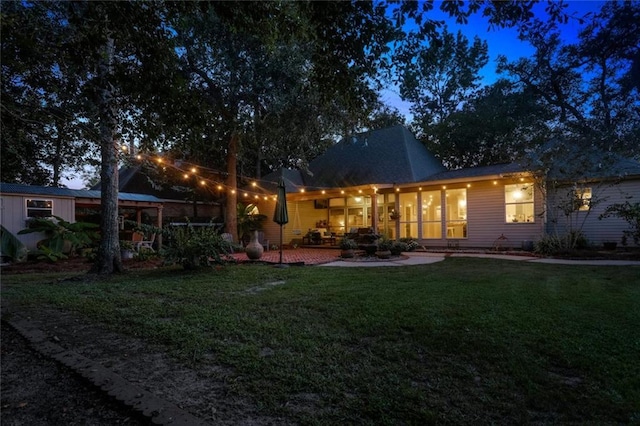 rear view of house with a lawn and a patio area