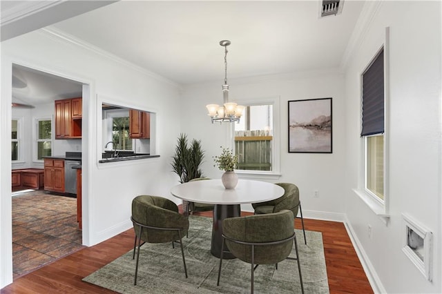 6415 Marshal Foch St, New Orleans, LA 70124 - dining room featuring a chandelier, dark wood finished floors, ornamental molding, and baseboards